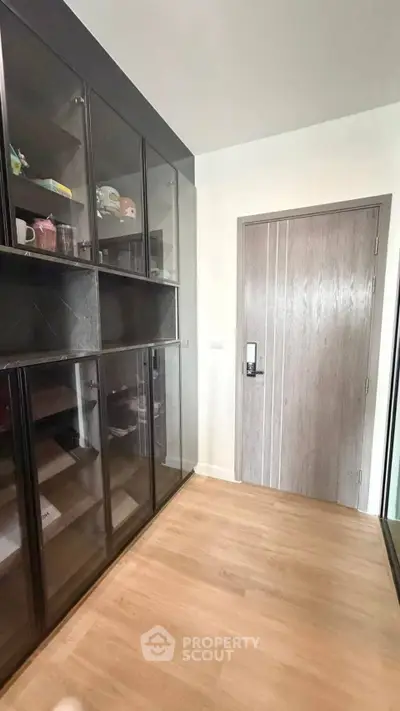 Modern storage room with sleek glass cabinets and wooden flooring