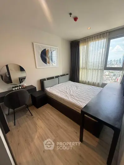 Modern bedroom with city view, featuring stylish decor and natural light.