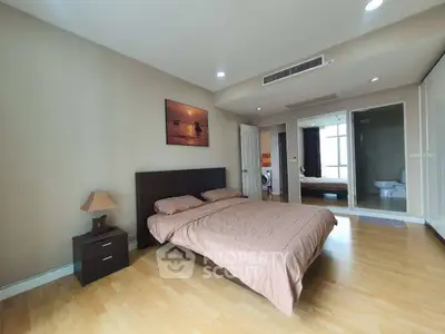Spacious bedroom with modern decor and ensuite bathroom in a luxury apartment.