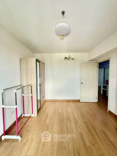 Spacious empty room with wooden flooring and wardrobe, ideal for customization.