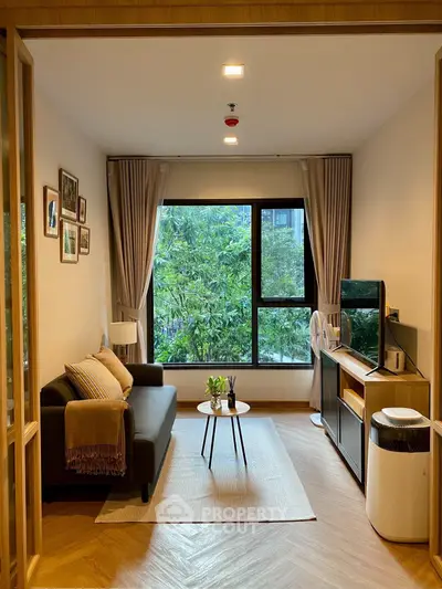 Charming living room with large window and cozy decor, perfect for relaxation and entertaining.