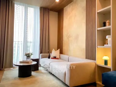 Modern living room with elegant sofa, stylish decor, and large window offering natural light.