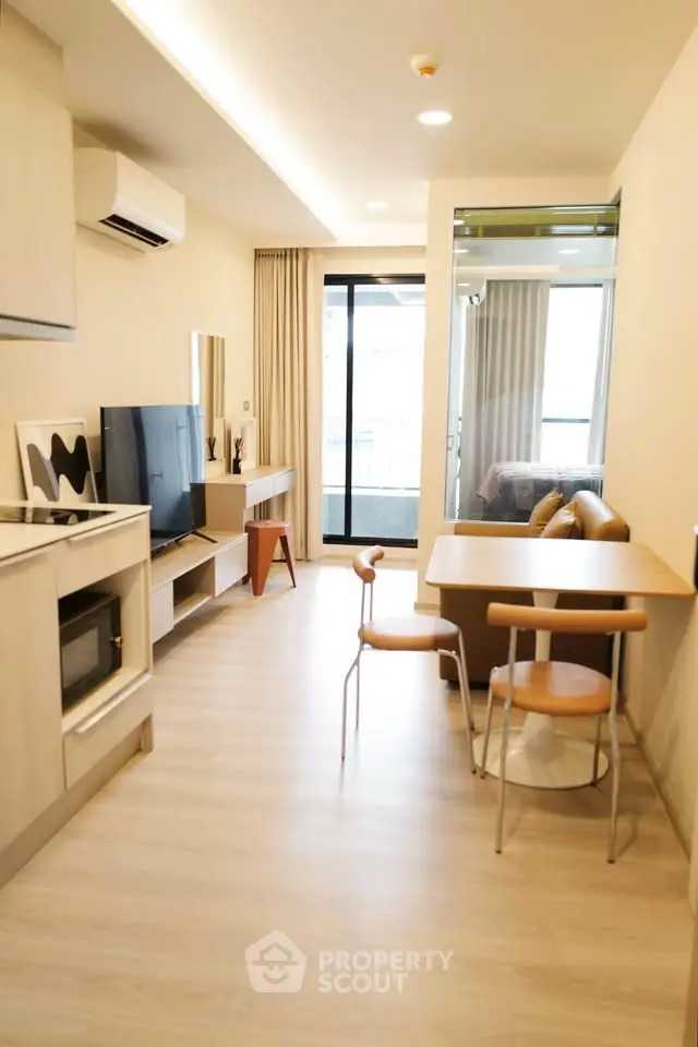 Modern living room with sleek furniture and balcony access in a stylish apartment.