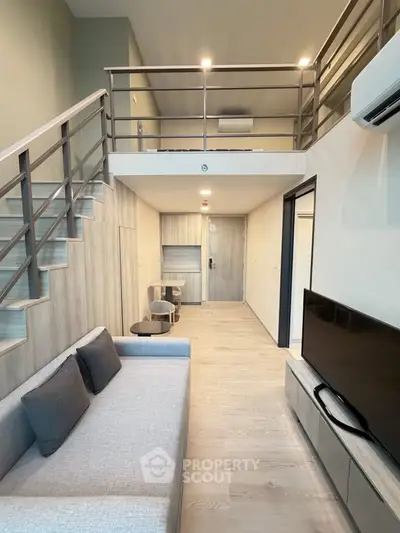 Modern loft-style living room with mezzanine, sleek furniture, and neutral tones for a spacious feel.