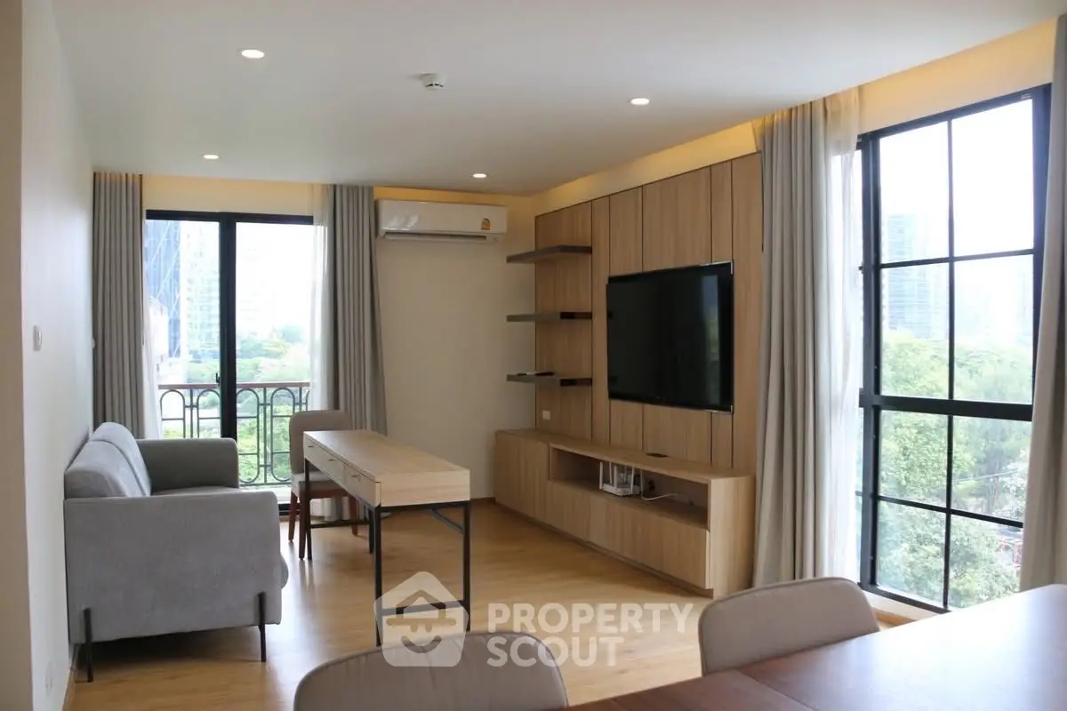 Modern living room with large windows and stylish furniture, offering a bright and inviting atmosphere.