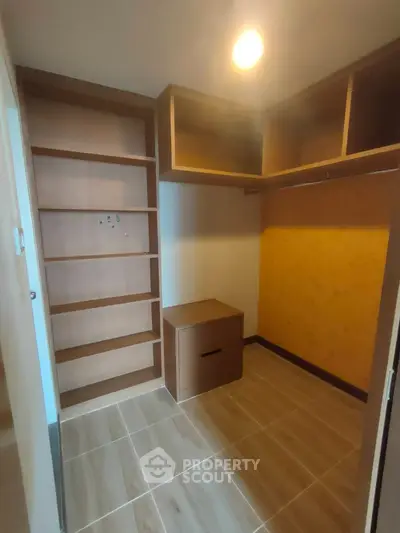 Spacious walk-in closet with built-in shelves and drawers in modern home
