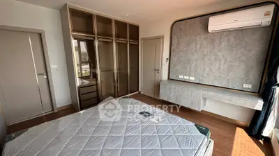 Spacious bedroom with modern design, featuring built-in wardrobe and air conditioning.