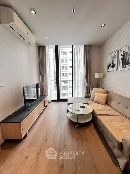 Modern living room with stylish decor and large windows in a high-rise apartment.