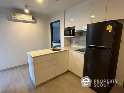 Modern kitchen with sleek cabinetry and high-end appliances, featuring a large refrigerator and built-in microwave, perfect for culinary enthusiasts.