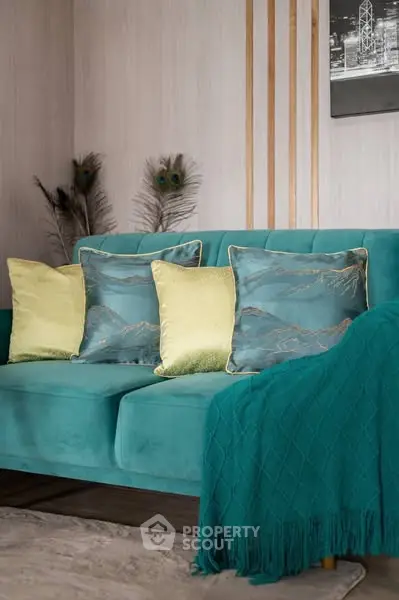 Elegant living room with teal sofa and decorative pillows, perfect for modern interiors.