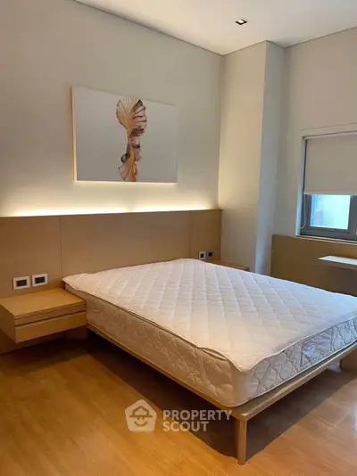 Modern minimalist bedroom with wooden flooring and stylish wall art