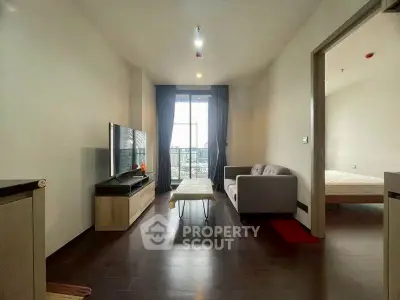 Modern living room with sleek furniture and city view from balcony.