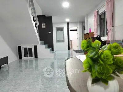 Spacious modern living room with staircase and large windows, perfect for family gatherings.