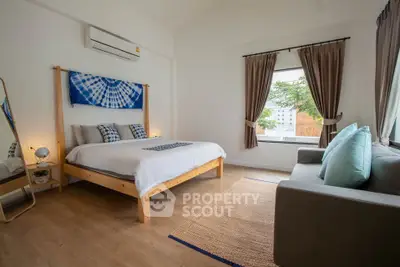 Spacious bedroom with modern decor and large window view