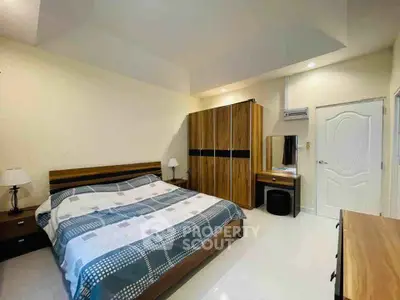 Spacious bedroom with modern furnishings and ample storage space.