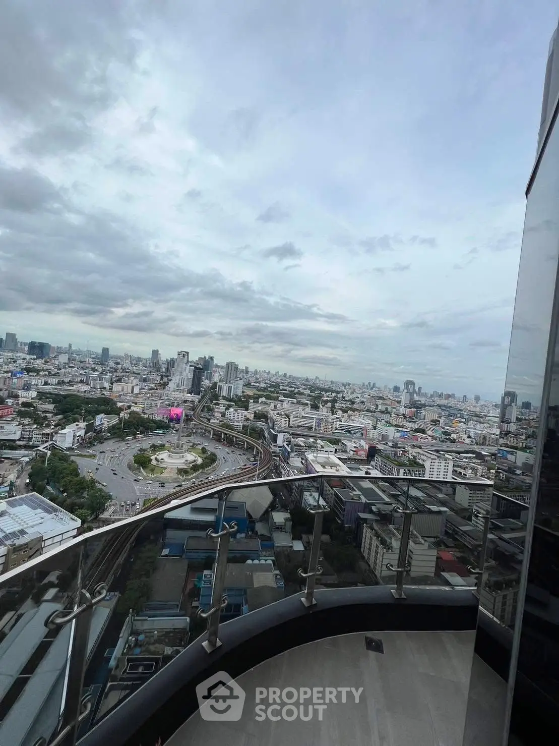 Stunning cityscape view from a high-rise balcony with sleek railing design.