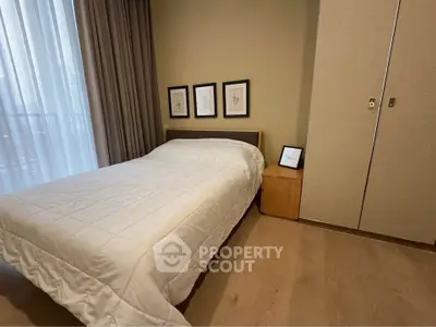 Cozy bedroom with modern decor and ample natural light, featuring a comfortable bed and stylish wardrobe.