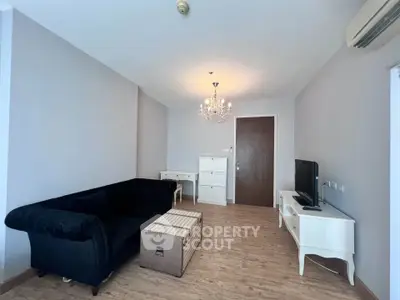 Elegant living room with chandelier and modern furniture in cozy apartment.
