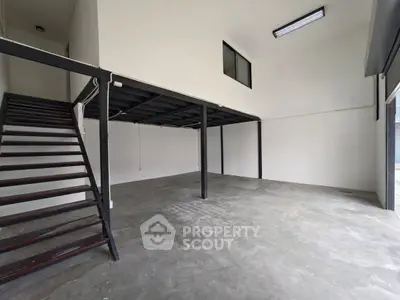 Spacious industrial-style loft with open floor plan and mezzanine level, ideal for creative workspace or studio.