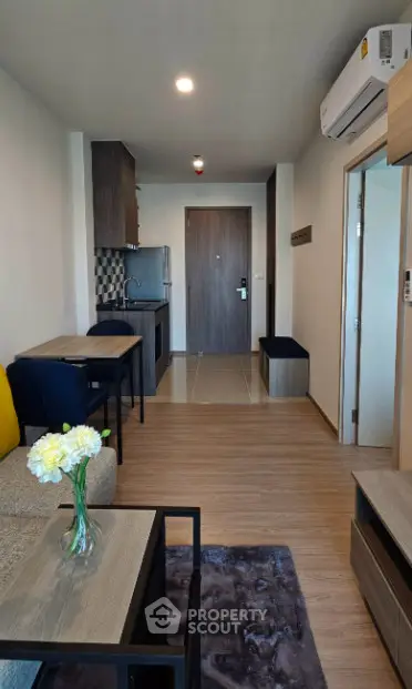 Modern apartment interior with open layout, featuring cozy living area and compact kitchen.