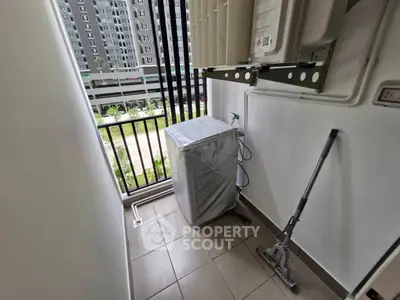 Compact balcony with washing machine and city view, ideal for urban living.