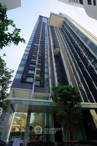 Stunning modern high-rise building with sleek design and lush greenery, perfect for urban living.