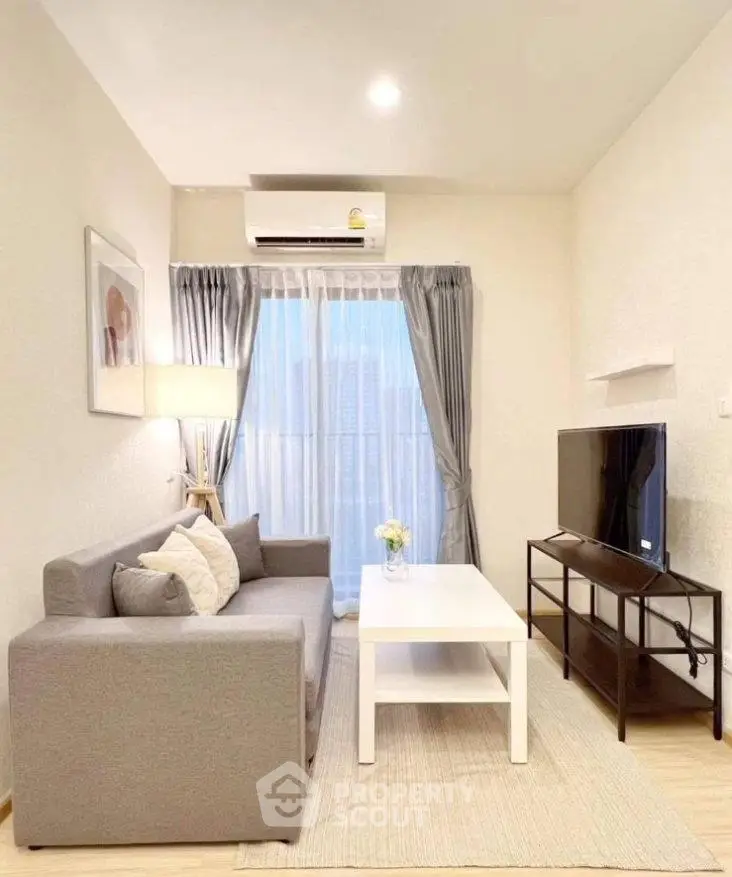 Cozy modern living room with gray sofa, white coffee table, and large TV, perfect for relaxation.