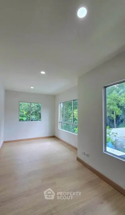 Spacious empty room with large windows and natural light, perfect for customization.