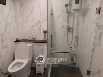 Modern bathroom with marble tiles and glass shower enclosure