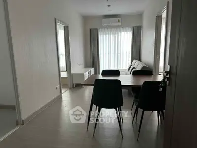 Modern dining area with sleek table and chairs, bright natural light, and minimalist decor.
