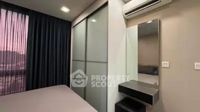 Modern bedroom with sleek wardrobe and air conditioning, featuring elegant curtains and a stylish vanity mirror.