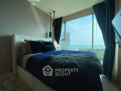 Luxurious bedroom with stunning city and sea view, featuring elegant decor and floor-to-ceiling windows.