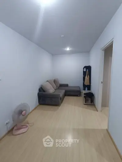Cozy living room with modern sofa and wooden flooring, perfect for relaxation.