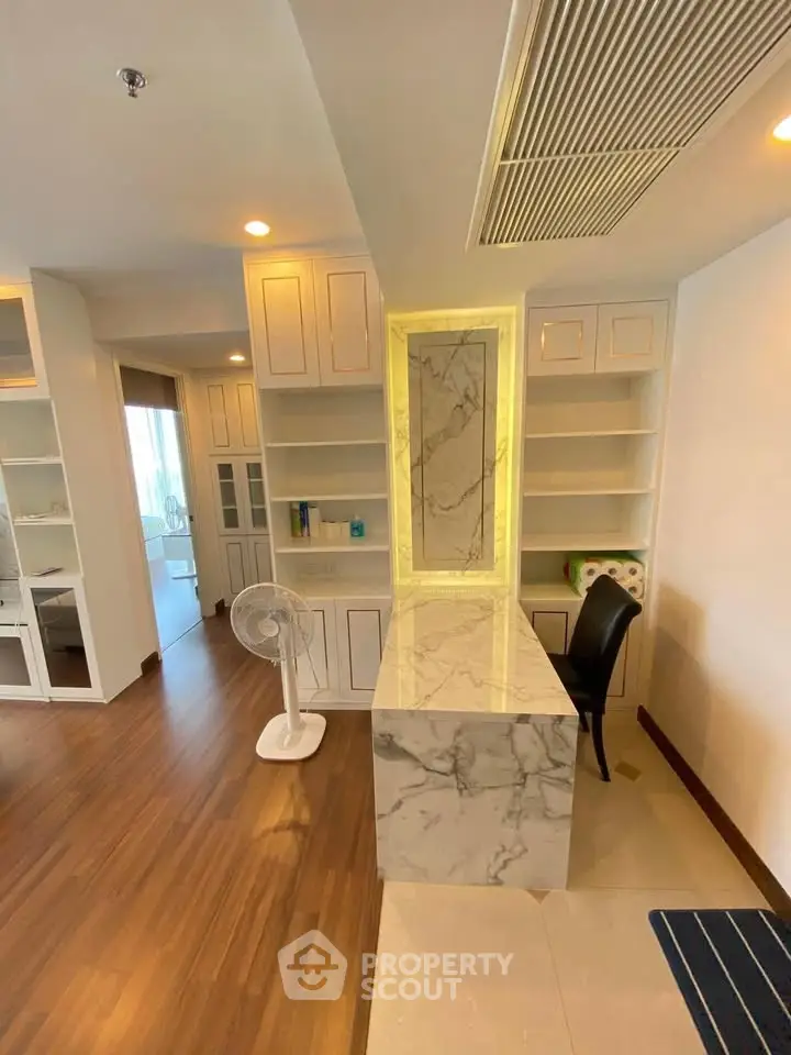 Luxurious modern interior with marble accents and built-in shelving, perfect for stylish living.