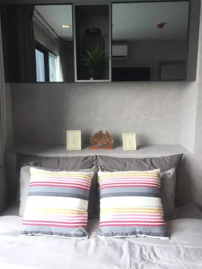 Cozy bedroom with stylish decor and colorful pillows, perfect for relaxation.