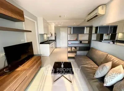 Modern living room with sleek furniture and open kitchen layout in a stylish apartment.