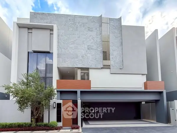 Modern architectural facade of a luxury residential building with sleek design and spacious garage.