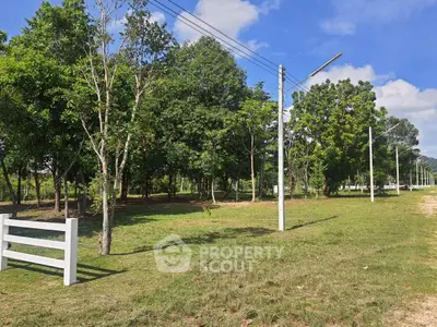 Spacious land plot with lush greenery and clear blue sky, ideal for development or investment opportunities.
