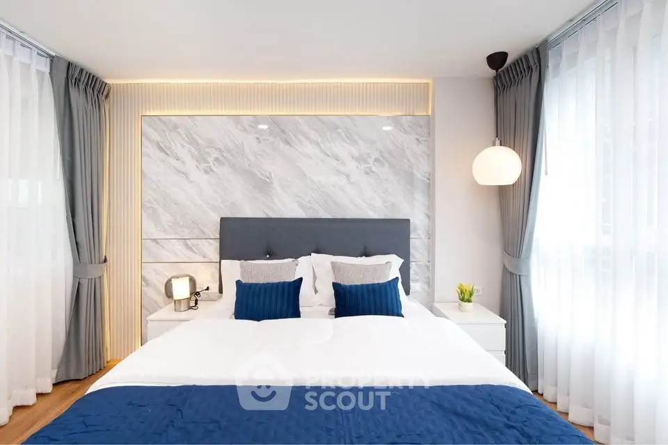 Luxurious bedroom with elegant decor and natural light, featuring a plush bed and stylish curtains.