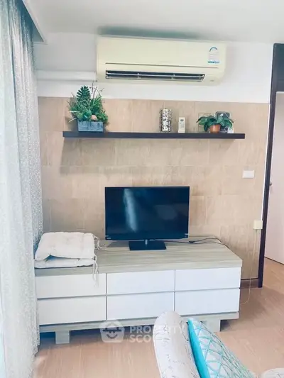 Modern living room with air conditioning and stylish decor, featuring a TV and sleek furniture.