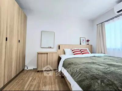 Modern bedroom with wooden furniture and cozy decor, featuring a large bed and ample natural light.