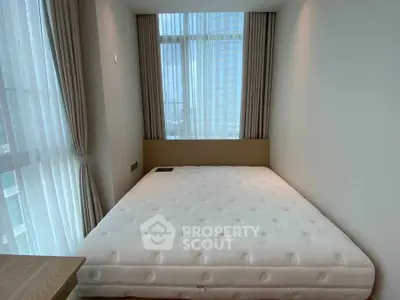 Modern bedroom with large window and minimalist decor in high-rise apartment.