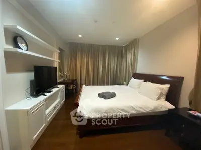 Spacious bedroom with elegant wooden flooring and modern furnishings