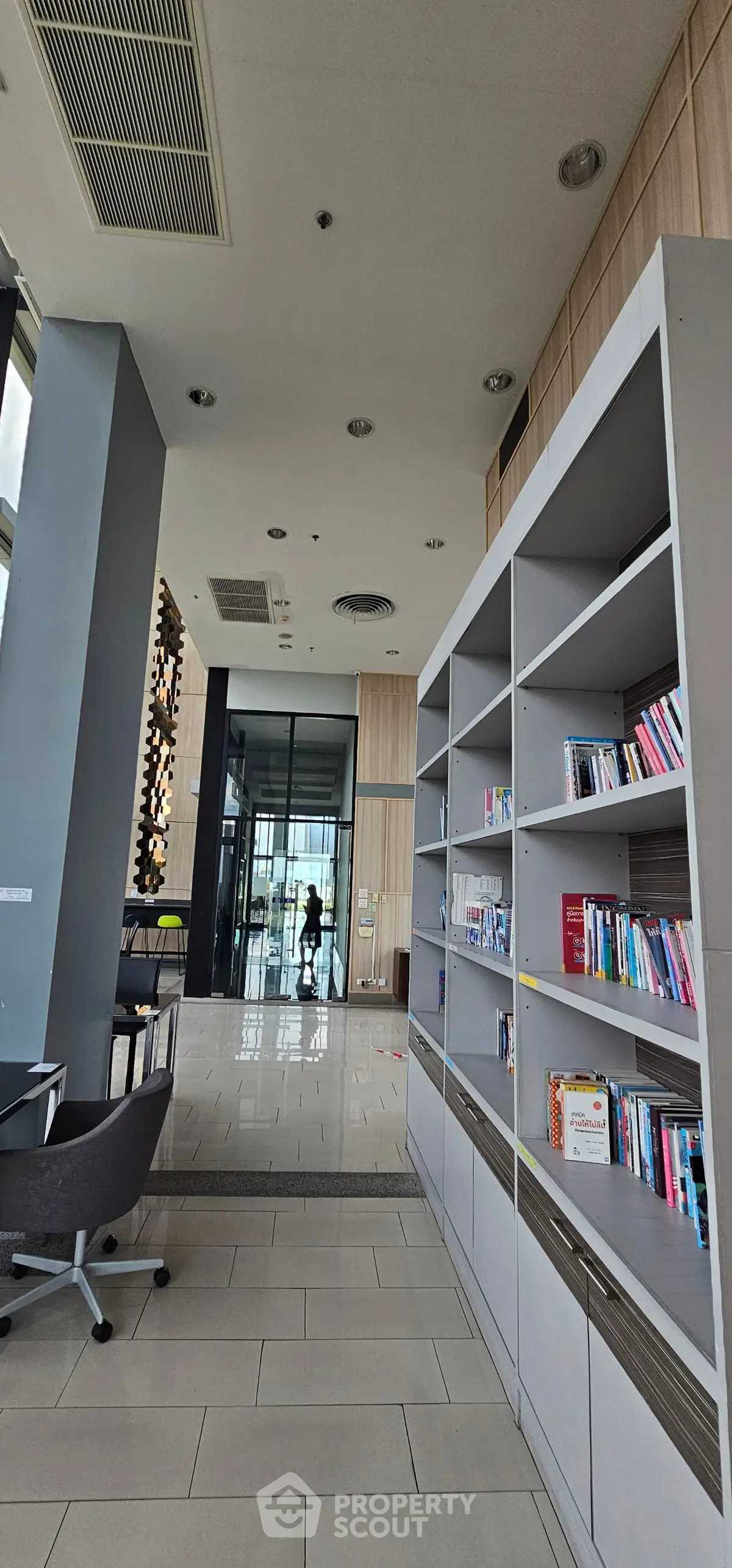 Modern library space with bookshelves and seating in a contemporary building