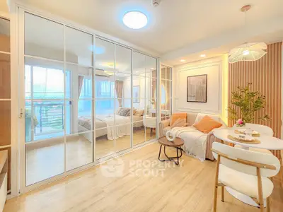 Bright and modern living room with mirrored closet doors and cozy dining area in a stylish apartment.