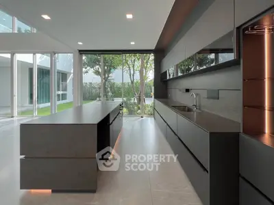 Luxurious modern kitchen with sleek cabinetry and large windows offering garden views.