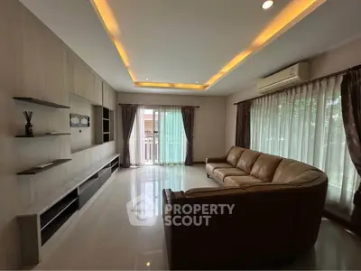 Spacious living room with modern lighting and large windows for natural light.