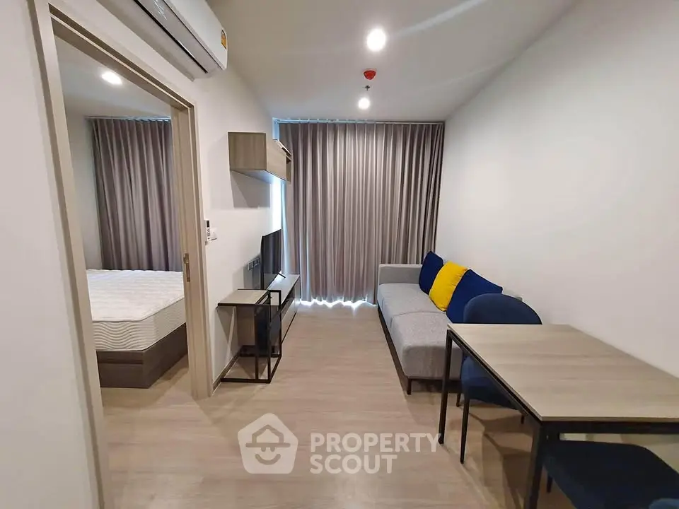 Modern living room with sleek furniture and bedroom view in a stylish apartment.