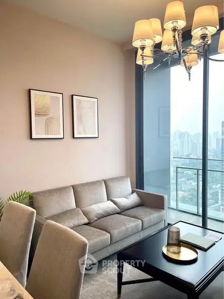 Modern living room with elegant chandelier and city view from large window.