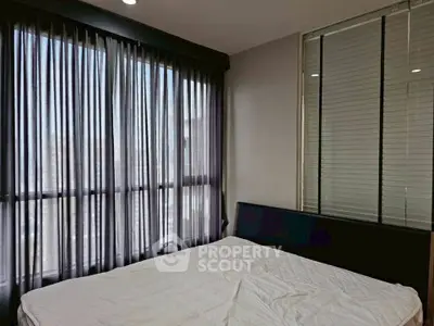 Modern bedroom with large windows and stylish curtains in a cozy apartment.